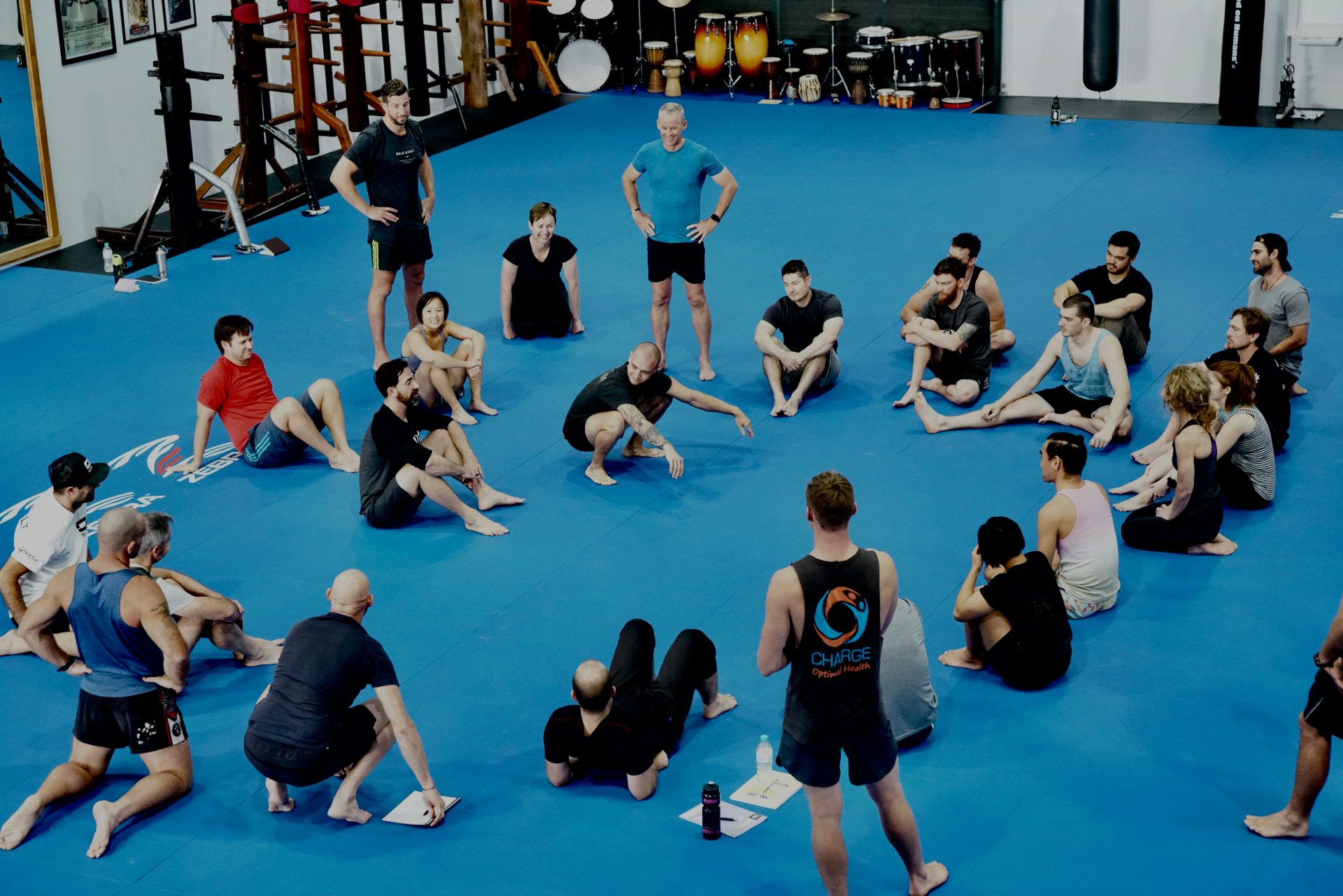 Group sitting in a circle on a blue mat